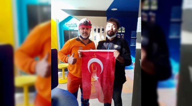 Enkazdan çıkan bayrağı duyarlı çalışana teslim etti