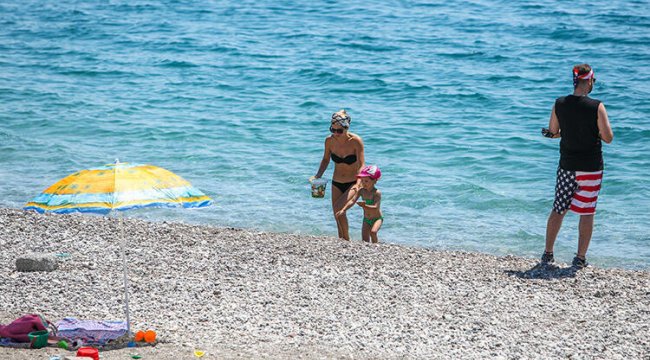 Antalya'da turistlerin boş sahilde denize keyfi