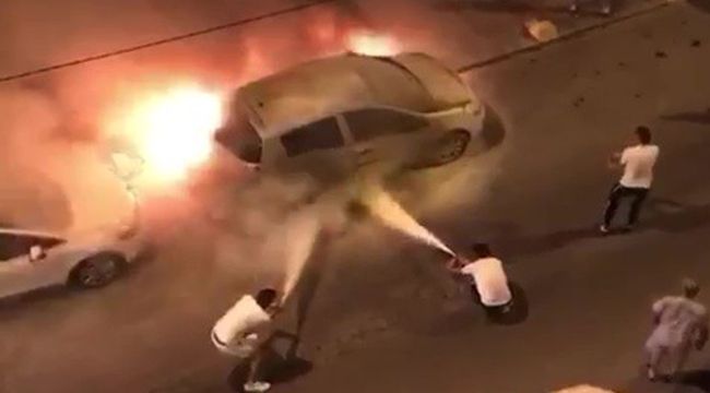 Alevler içinde kalan aracı yangın tüpüyle söndürmeye çalıştılar