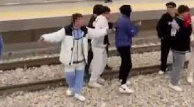 Bir grup genç, istasyonda metro raylarına indi
