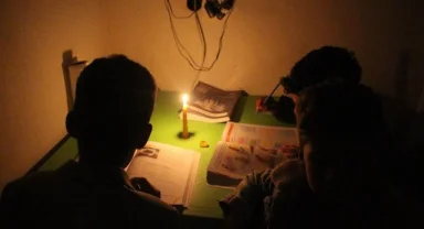 Öğrenciler mum ışığında ders çalışıyor