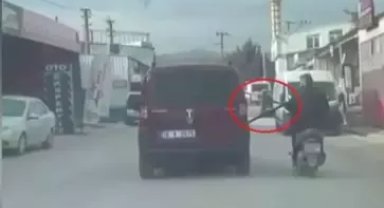 Motosikleti arızalanan sürücü, başka araçtan uzatılan emniyet kemerini tutup seyretti